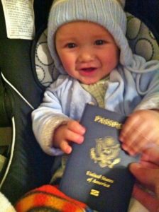 Baby holding a passport ready to travel on a plane. Baby plane travel guide.