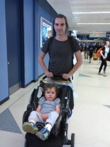 Dad pushing baby in a stroller through airport